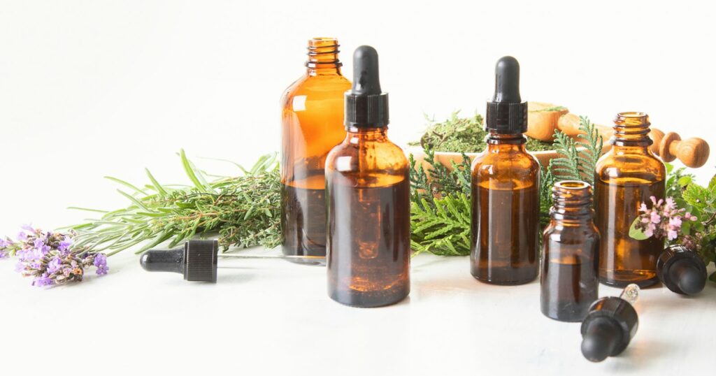 Essential oils and herbs on white background.