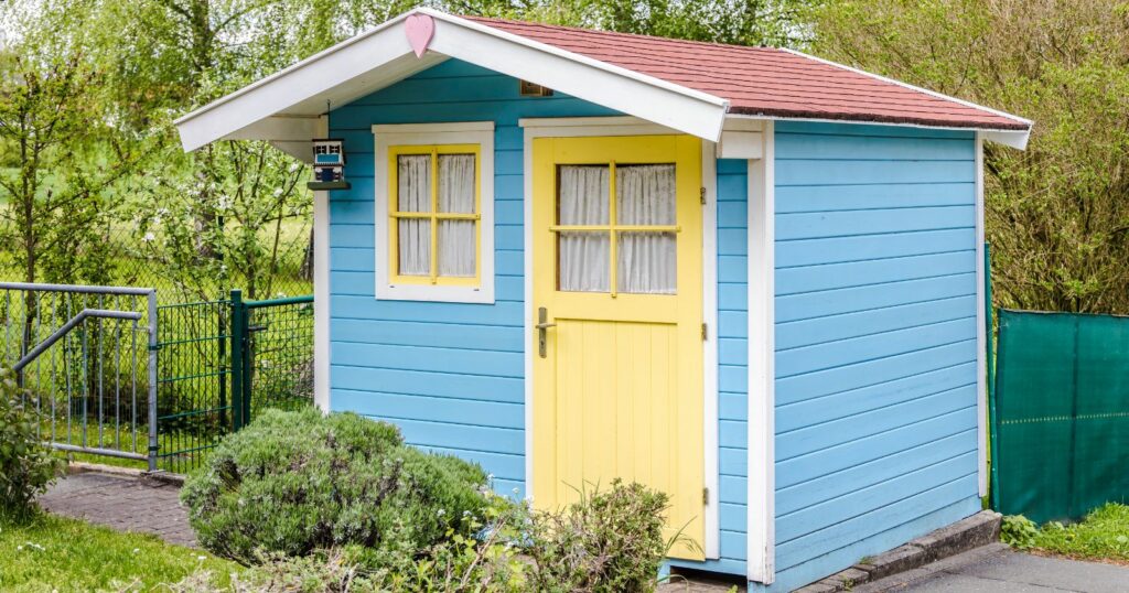 Modern blue and yellow garden shed with door.