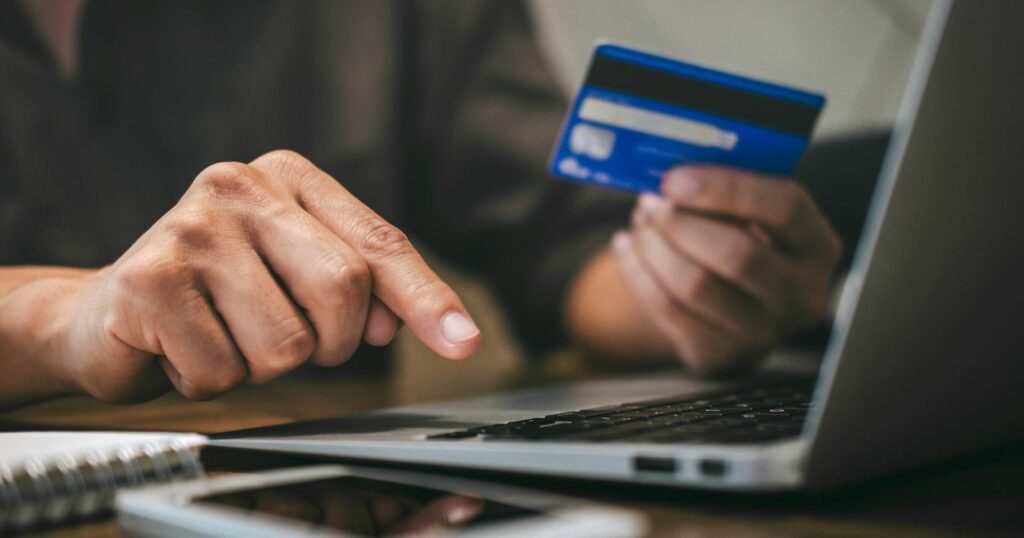 A person using a credit card to make a payment at a store counter.